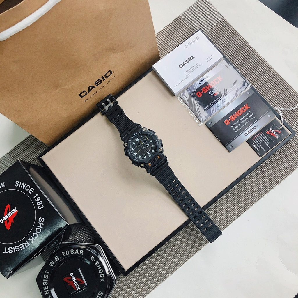 Casio G-Shock wristwatch with black strap and orange accents, shown with packaging