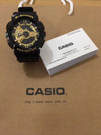 G-Shock watch with black resin strap and gold dial, gold-tone hands.