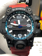 Casio G-Shock wristwatch close-up with black case, blue bezel accent, red strap