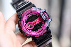 Casio G-Shock watch with black strap and bright pink bezel, red-accent dial, digital display