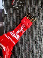 Red Casio G-Shock strap close-up with printed pattern and gold-tone clasp