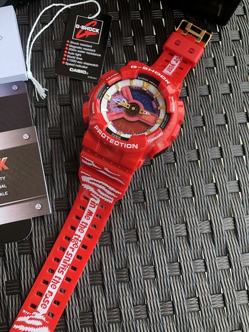 Red Casio G-Shock watch laid diagonally, textured red strap with raised lettering