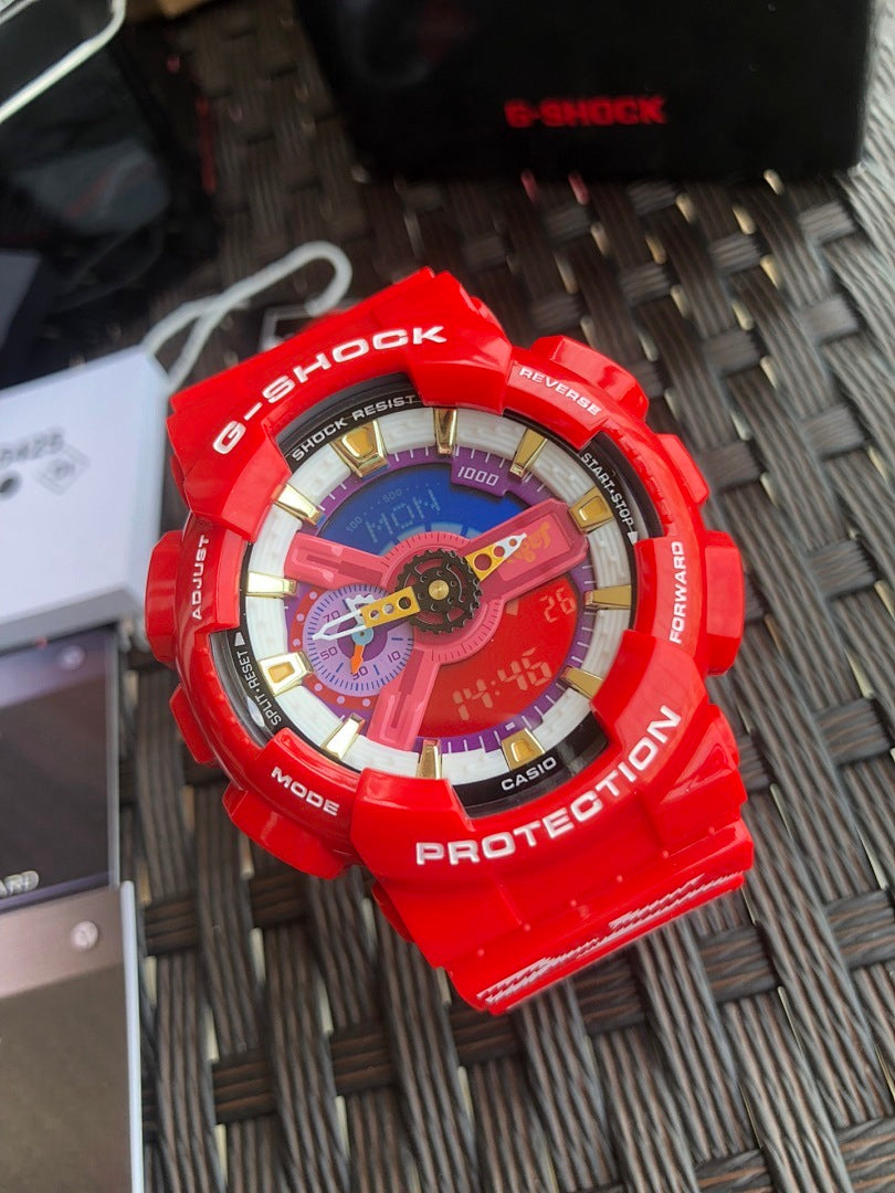Red Casio G-Shock wristwatch, colorful dial with gold markers on textured mat