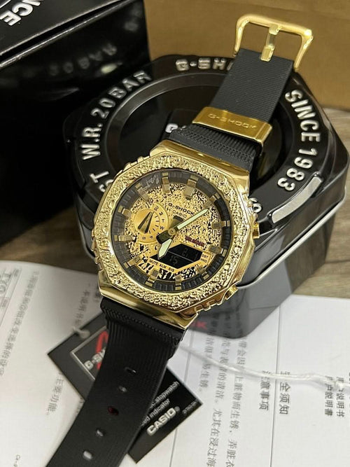 Casio G-Shock watch with gold bezel, black strap, black dial with gold details