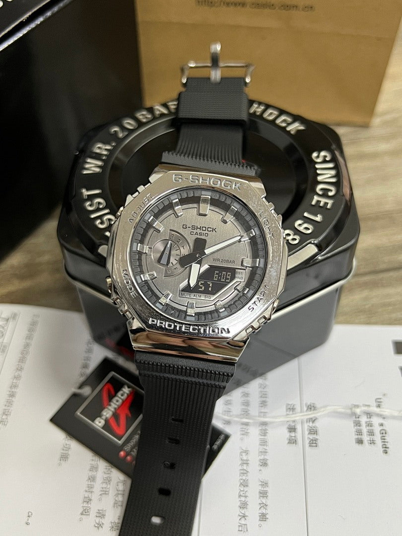 Casio G-Shock watch with silver case, black strap, gray dial with stopwatch display
