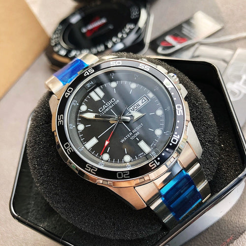 Casio watch with black dial, silver bezel, blue accent strap, on black cushion