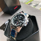 Casio watch with black dial, silver case, and blue strap links, in black box