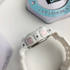 White Casio watch with metal buckle and pink strap markers, side close-up