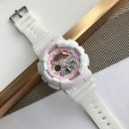 White Casio watch with pink dial and white resin strap, angled view with clasp
