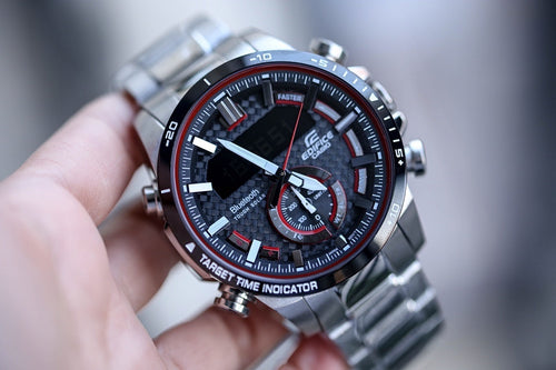 Casio watch with black dial, red details, and silver link bracelet