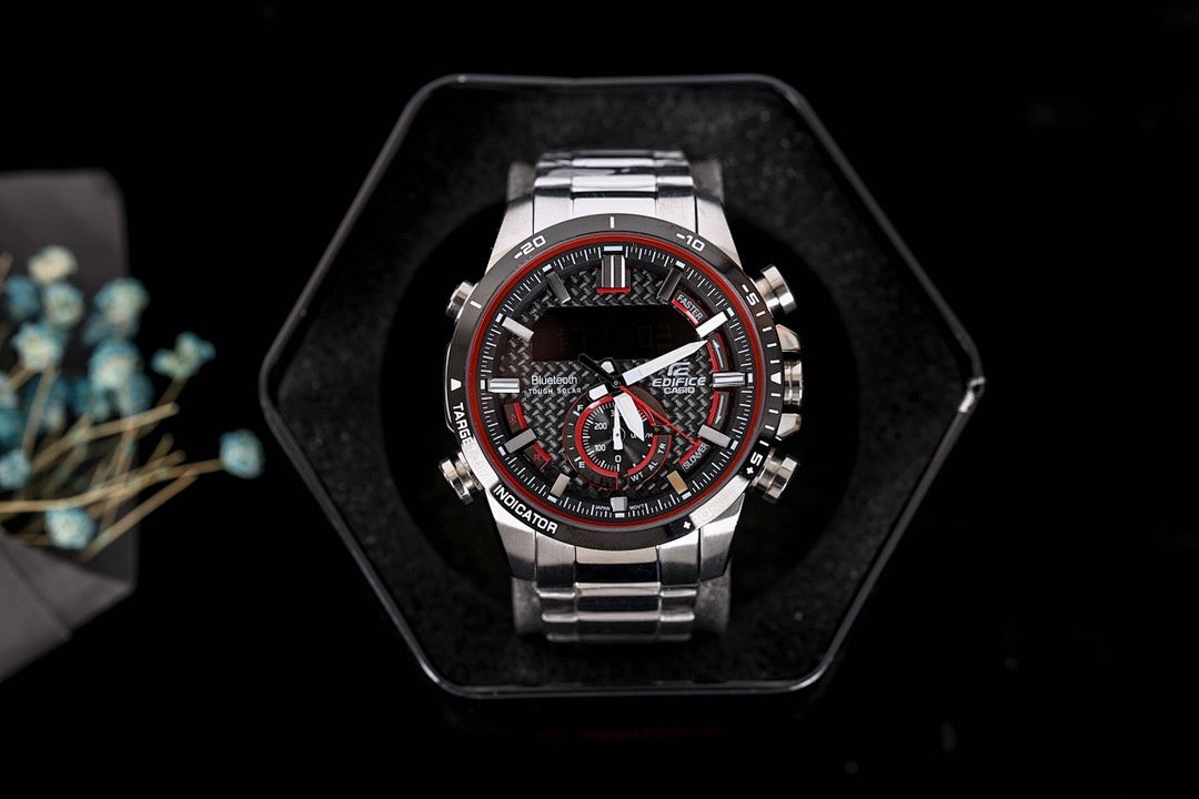 Casio watch on black display with round black dial and red/white subdials
