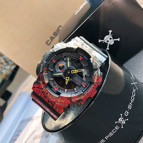 Casio G-Shock watch angled view, red-and-black patterned band, blue-gray dial detail