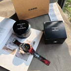 Casio G-Shock watch on display, red patterned band and blue-gray dial
