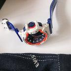 G-Shock watch top view with blue strap and white case with orange details