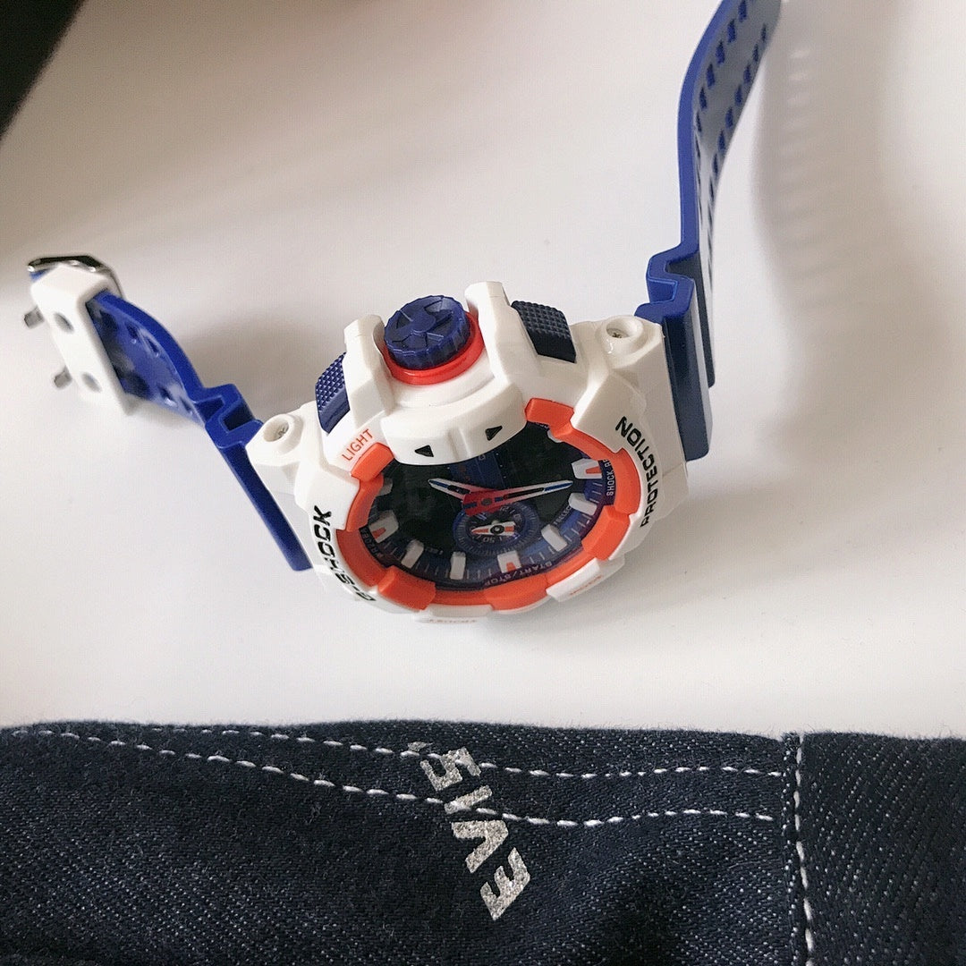 G-Shock watch top view with blue strap and white case with orange details