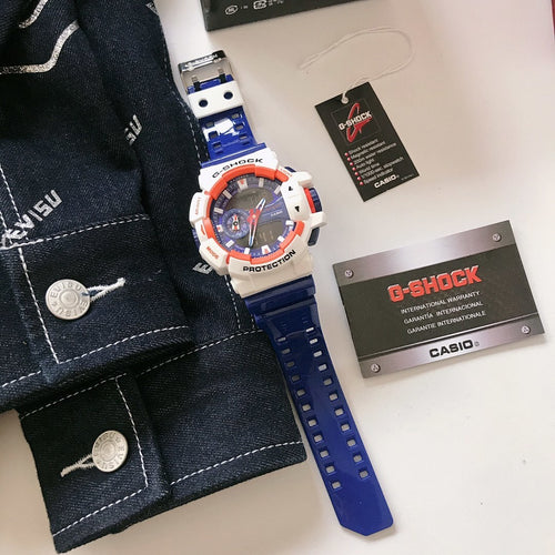 Casio G-Shock watch with blue silicone strap, white case, orange bezel detail