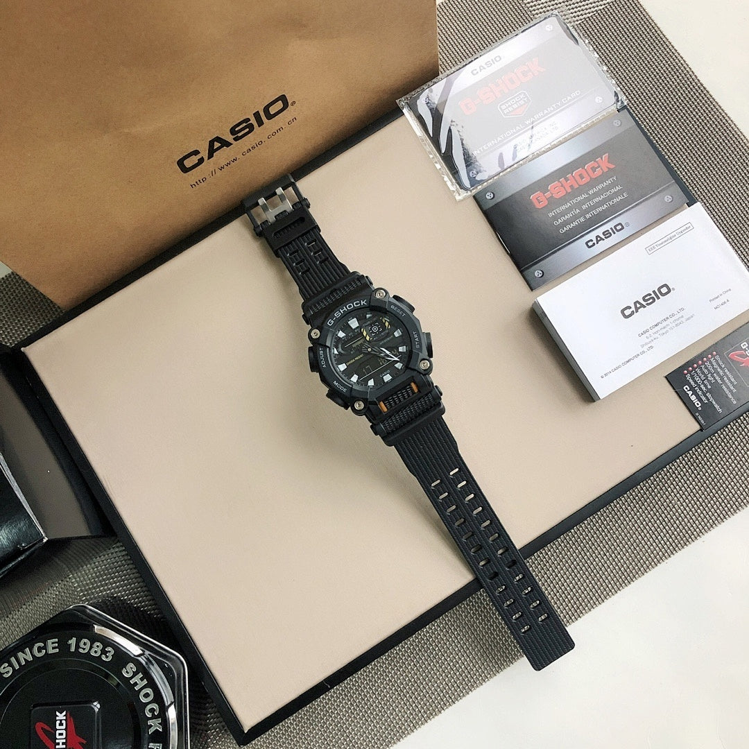 G-Shock wristwatch on tray with black resin strap, surrounded by boxes