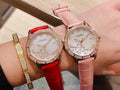 Chanel watch with pink leather strap and diamond bezel, floral dial close-up on wrist