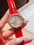 Chanel watch with red leather strap and diamond bezel, floral dial on hand