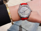 Chanel watch with red leather strap, white dial, diamond bezel, and flower details