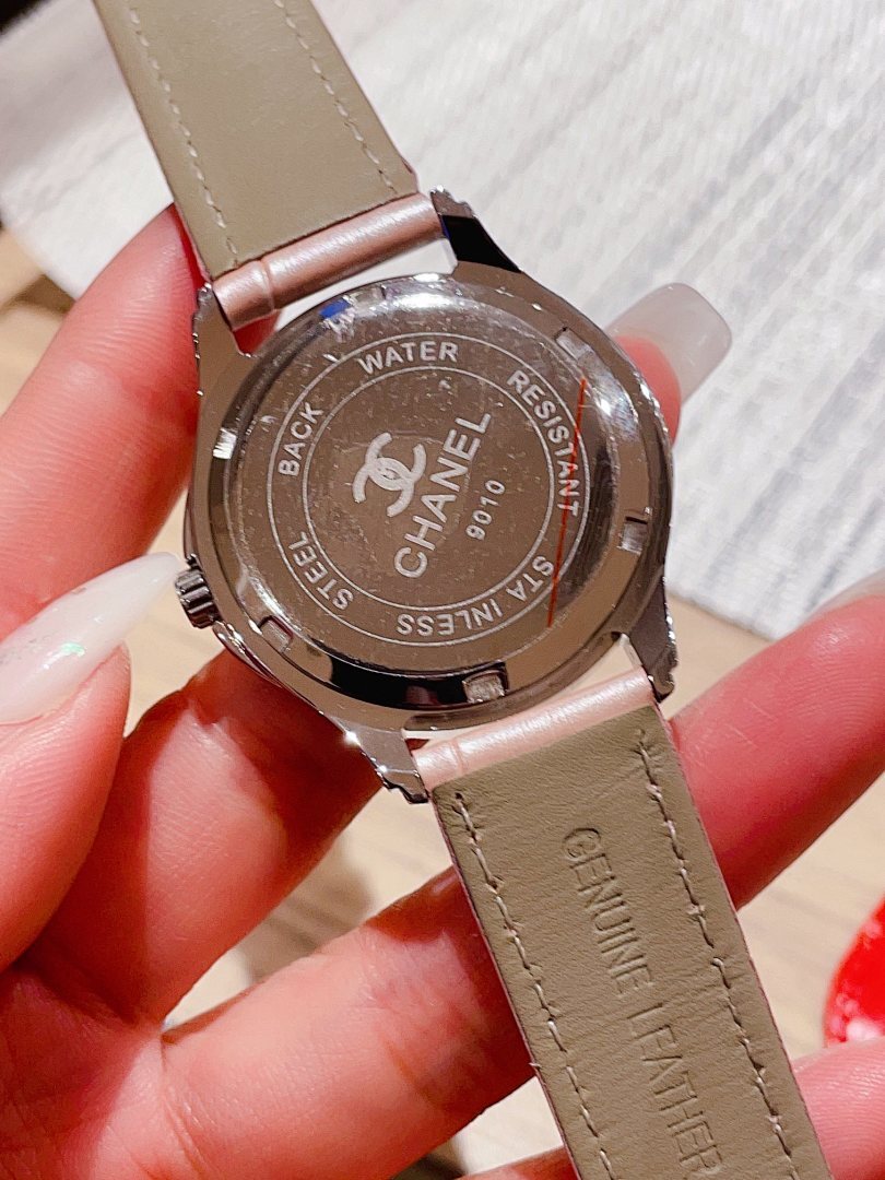 Chanel watch caseback with engraved text and light pink leather strap