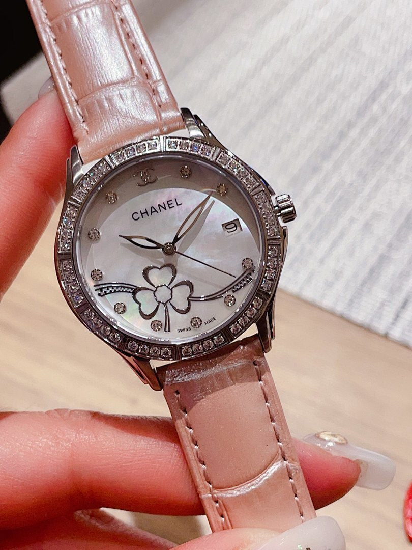 Chanel watch with light pink leather strap, white dial, diamond bezel, and flower details
