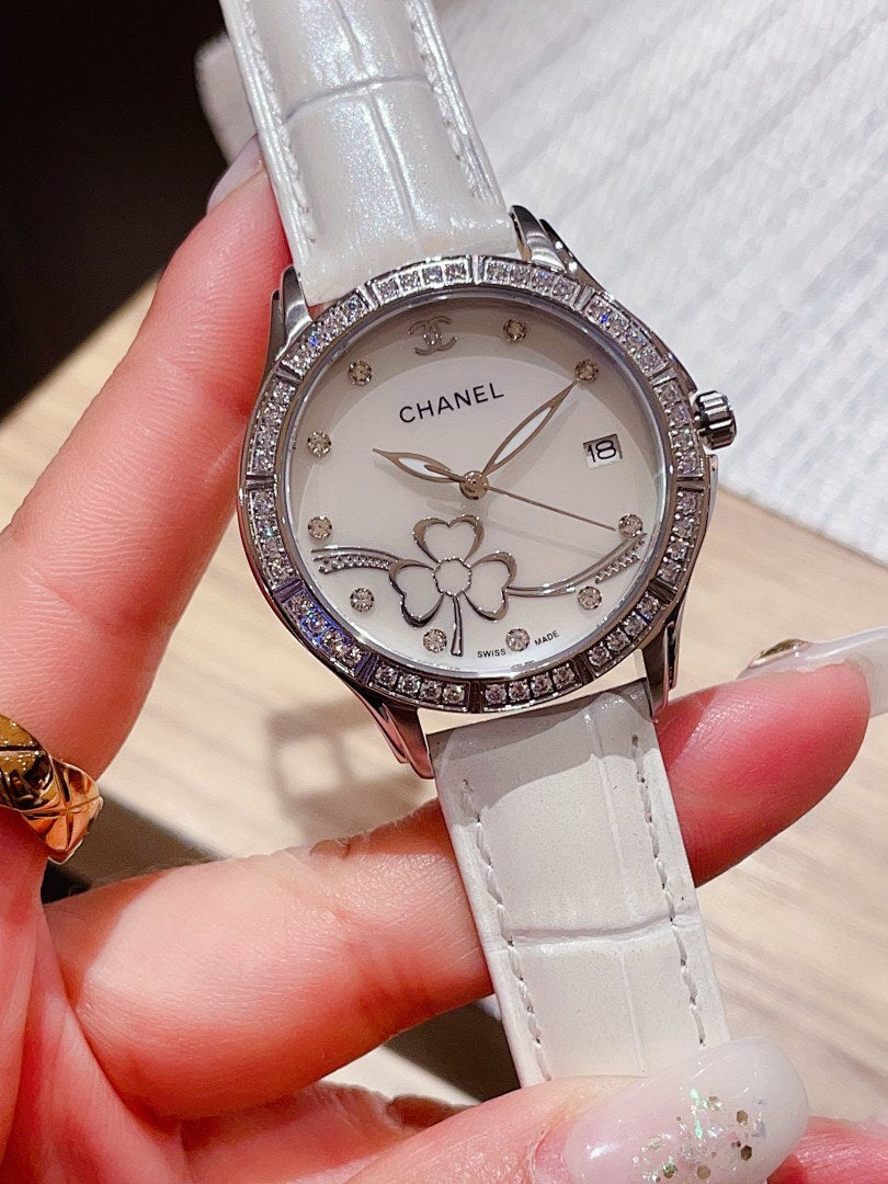 Chanel watch with white leather strap, white dial, diamond bezel, and flower details