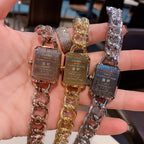 Assorted Chanel watches on chain bracelets with black and gold rectangular dials.