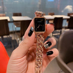 Gold-toned chain-link Chanel watch with black rectangular dial and crown detail.
