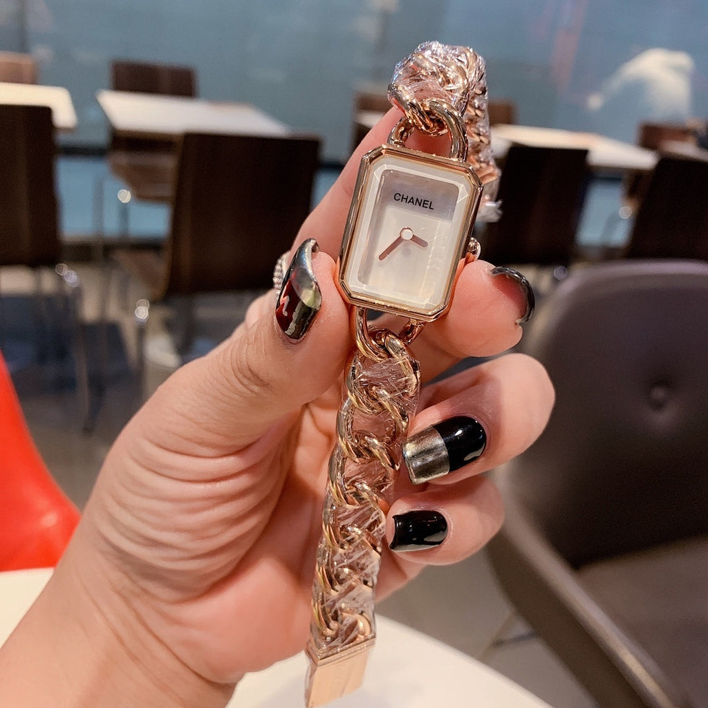 Gold-toned chain-link Chanel watch with white rectangular dial and slim bezel.