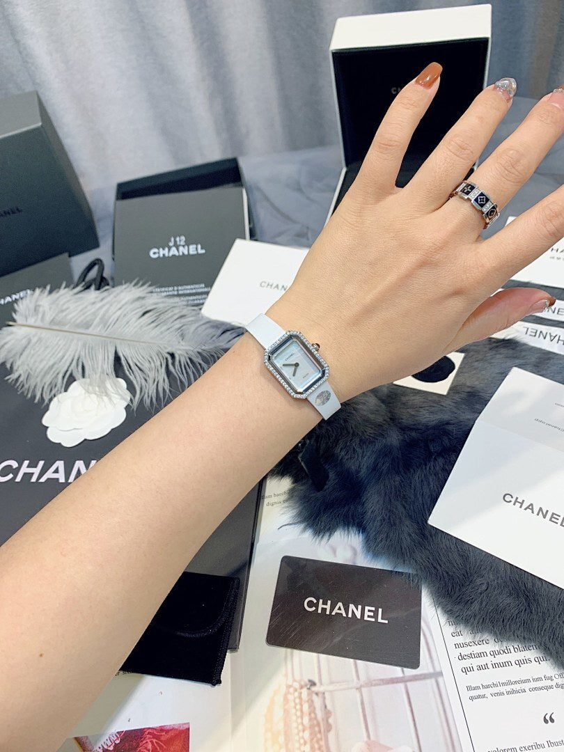 Chanel watch with light dial and white strap worn on wrist