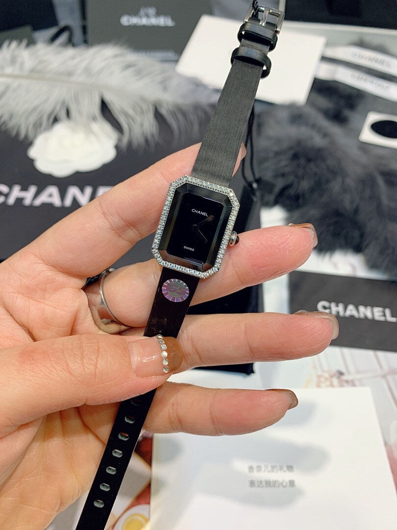 Chanel watch with dark dial, square crystal bezel, and black strap