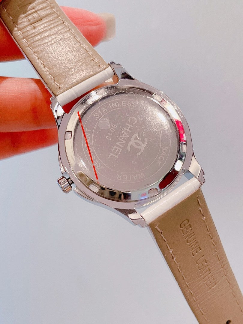 Luxury watch case back with engraved text and beige leather strap