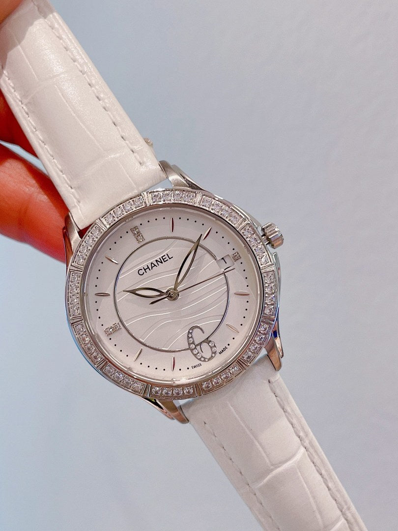 Luxury wristwatch with diamond bezel, white dial, and white leather strap