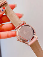 Chanel watch with tan leather strap and rose-gold round case, engraved back