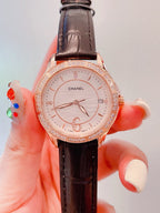 Chanel wrist watch with dark brown leather strap, rose-gold case, and jeweled bezel