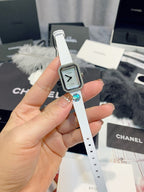 Chanel wristwatch with black square dial and diamond-like bezel on a white leather strap