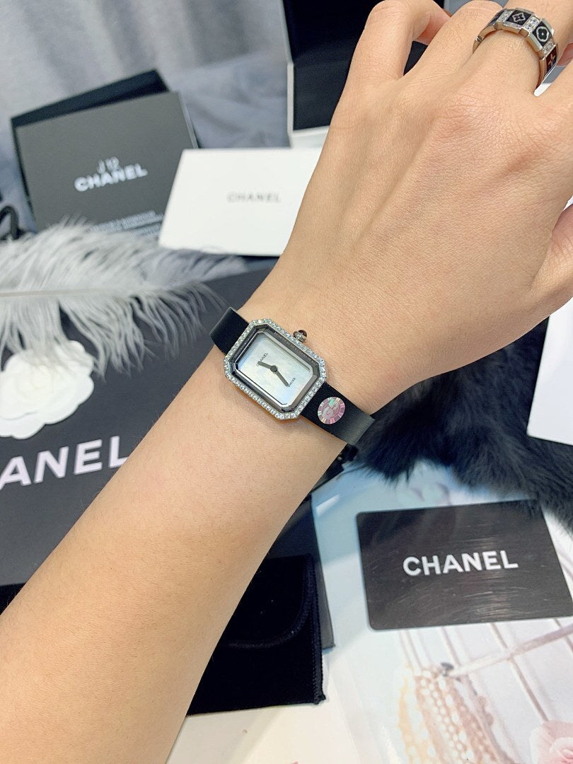 Chanel wristwatch on the wrist with silver square case and white leather strap