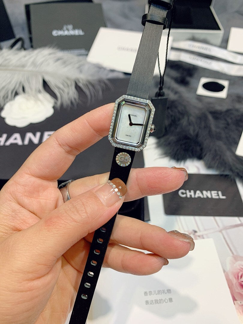 Chanel wristwatch close-up with light dial, silver square bezel, and dark leather strap