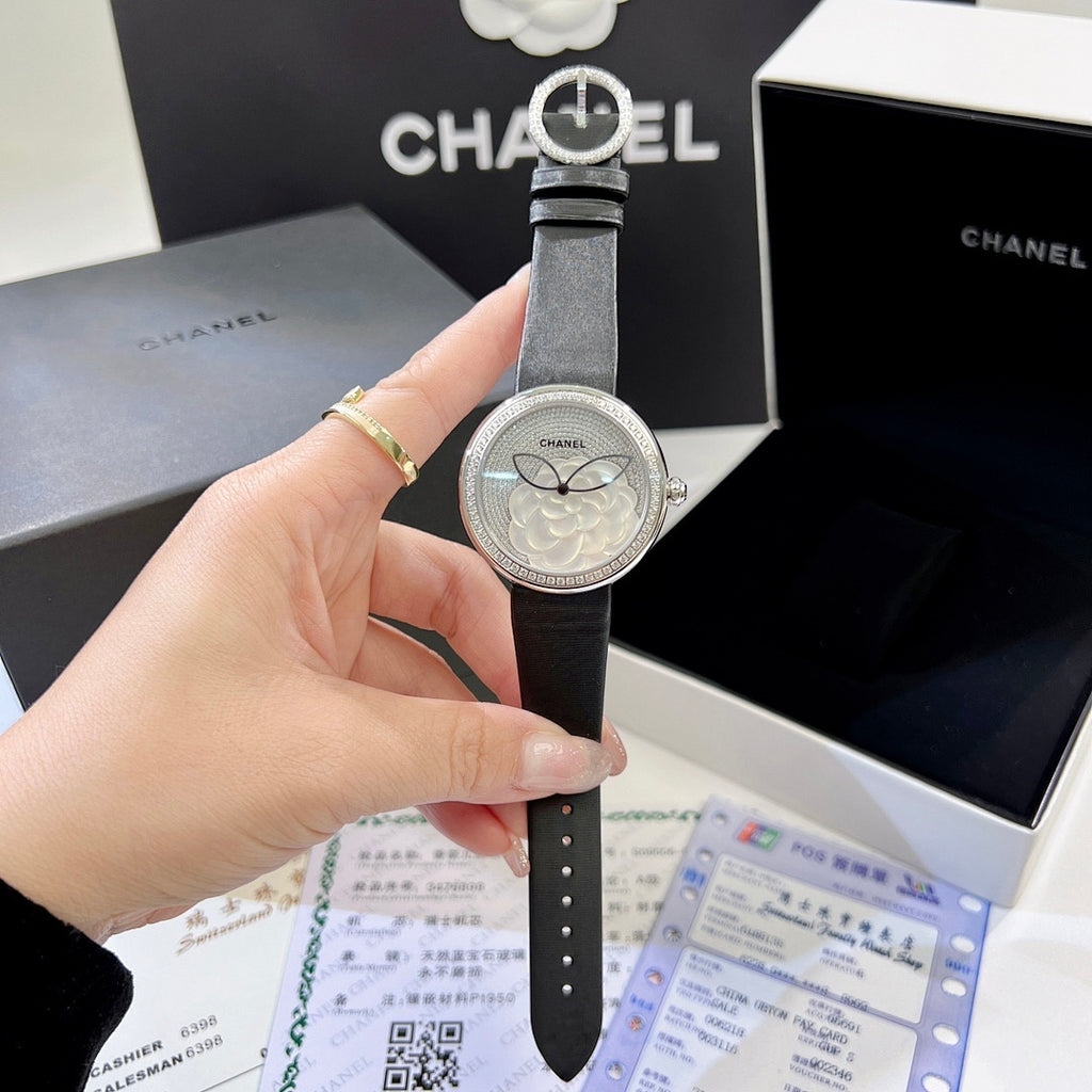 Chanel round wristwatch front view with black leather strap and silver bezel