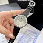 Chanel round wristwatch front view with black strap and embossed flower face