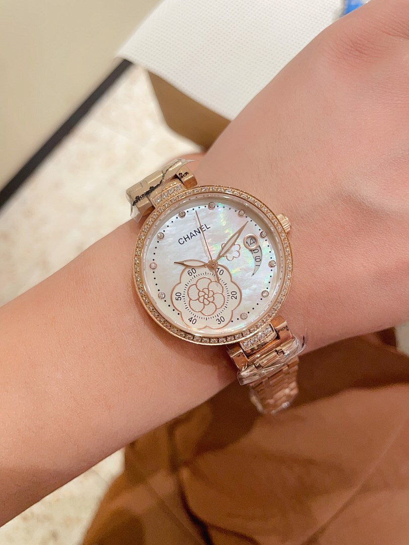 Chanel watch with rose-gold tone bezel and metal link bracelet, floral-style dial details