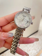 Chanel watch with silver-tone case and bezel, ornate dial, and silver metal link bracelet