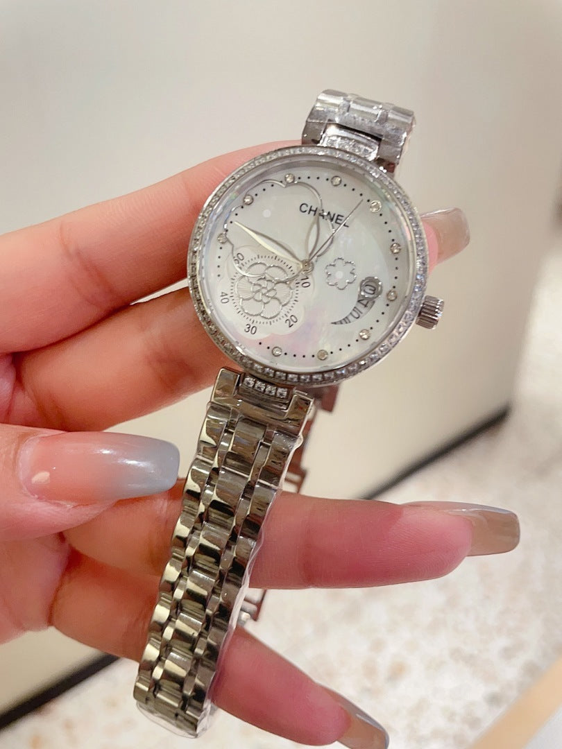 Chanel watch with silver-tone case and bezel, ornate dial, and silver metal link bracelet