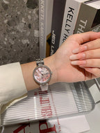 Chanel watch on wrist with silver bracelet and pale dial, round case