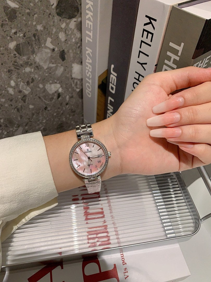 Chanel watch on wrist with silver bracelet and pale dial, round case