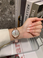 Chanel watch on wrist with silver bracelet and light dial, slim hands