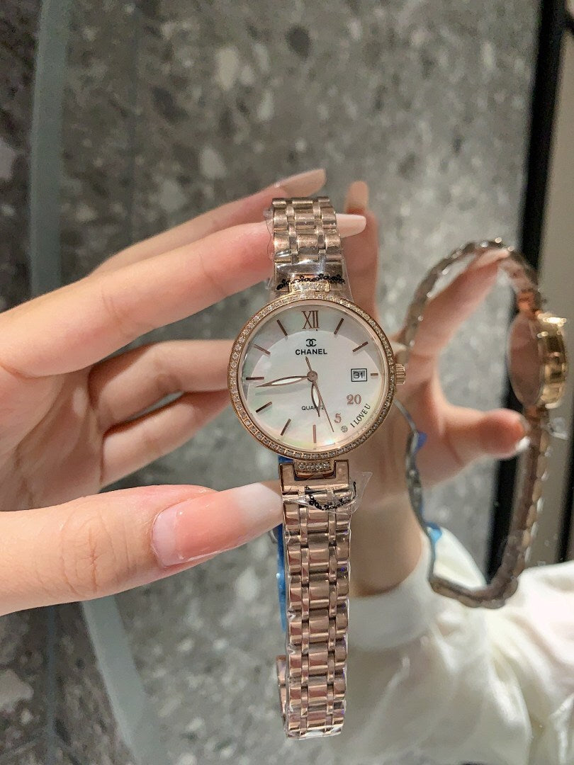 Chanel watch with white dial, silver bracelet, Roman numerals and marker dots