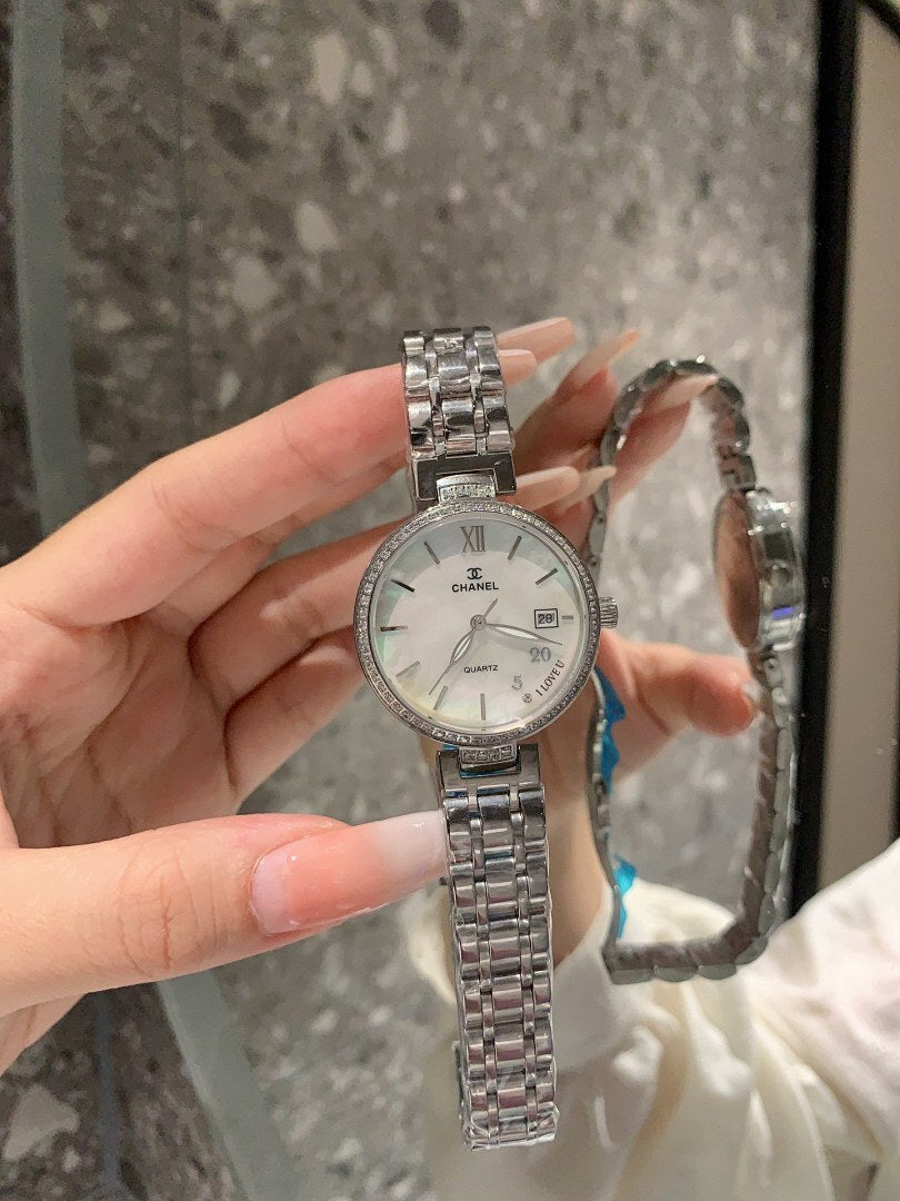 Chanel watch with pale dial and silver bracelet, round face close-up