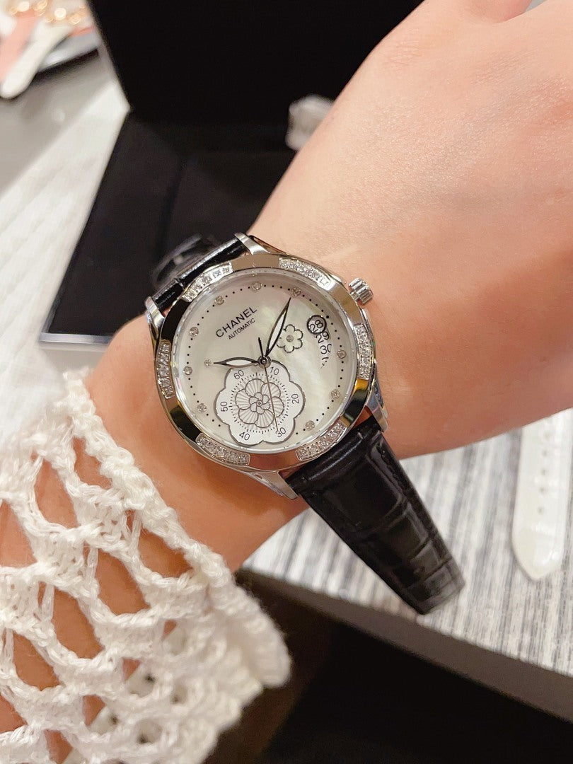 Chanel watch with black leather strap and silver floral butterfly dial